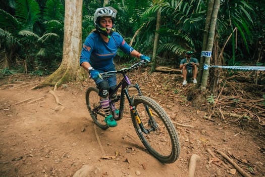 Female mountain biker navigates rugged forest trail with speed and skill.