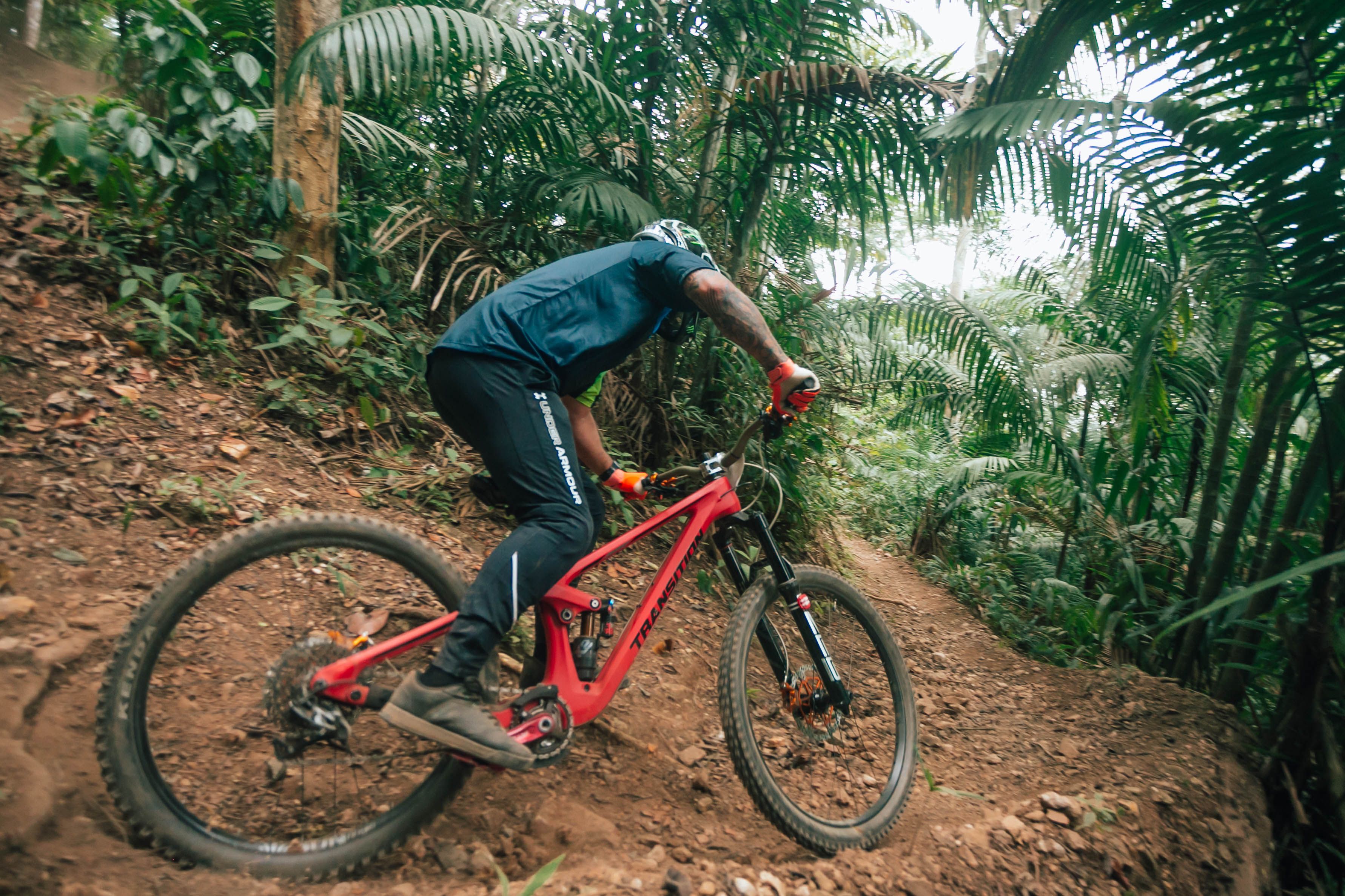 Experience the thrill of mountain biking on challenging trails through a lush tropical forest.