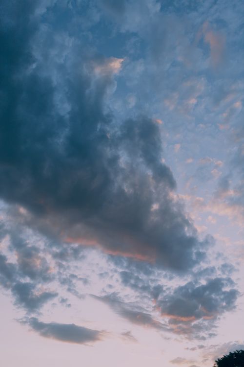 Free A captivating photo of a cloudy sky during twilight, showcasing dramatic colors. Stock Photo