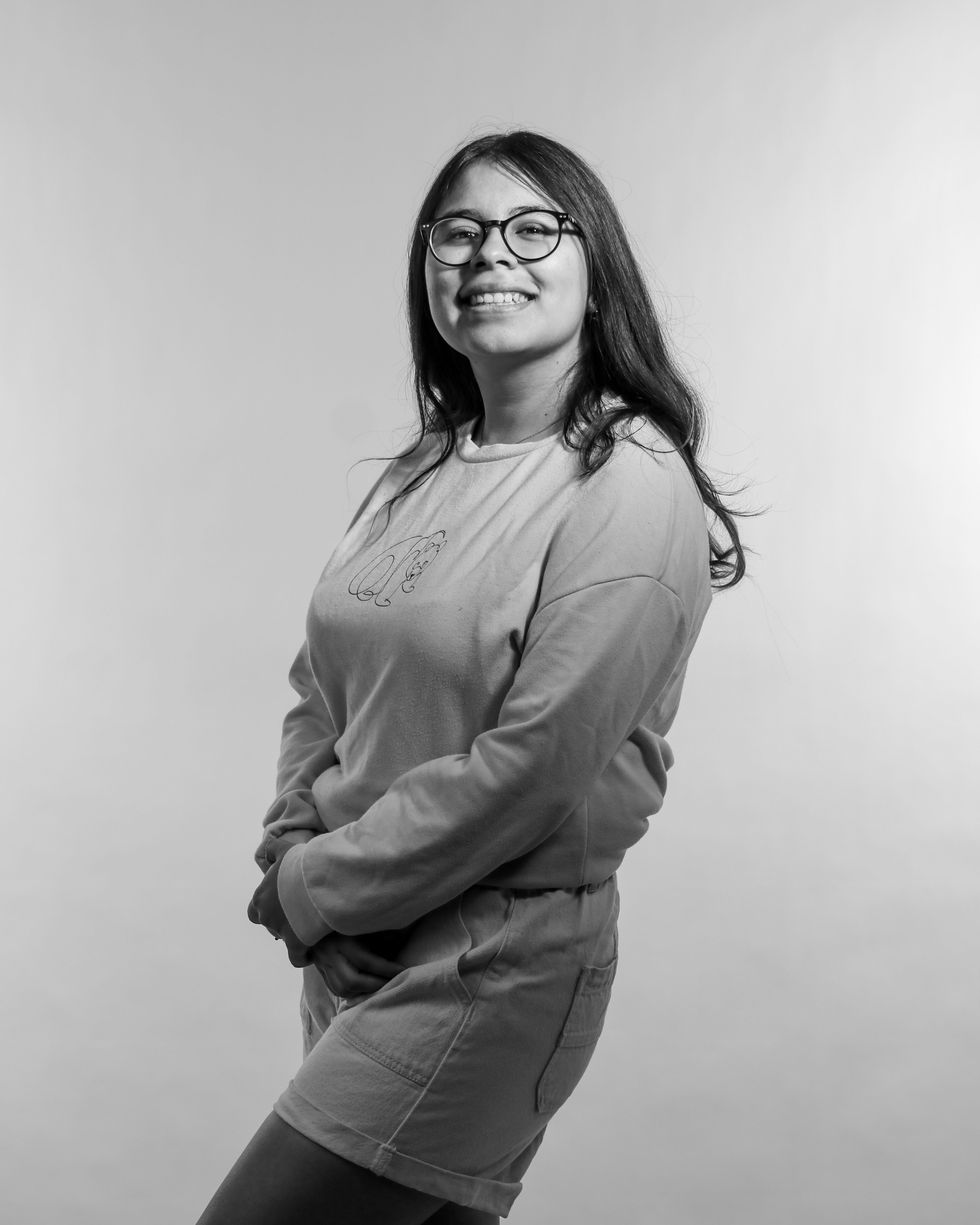 A woman in glasses and a shirt posing for a black and white photo ...