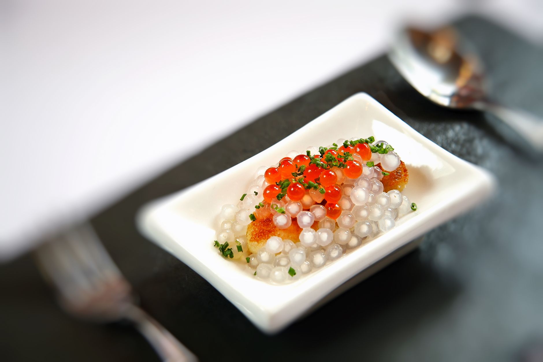 Close-up of caviar with blini and garnishes