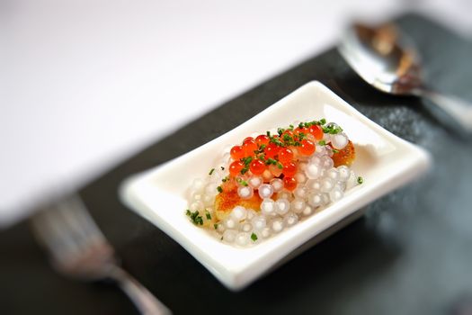 Luxurious gourmet caviar dish served on a small plate with artistic presentation in fine dining setting.