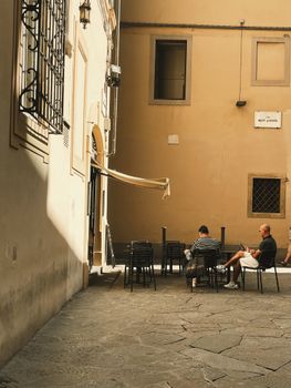 A serene courtyard scene with people relaxing in Florence, Tuscany, Italy.