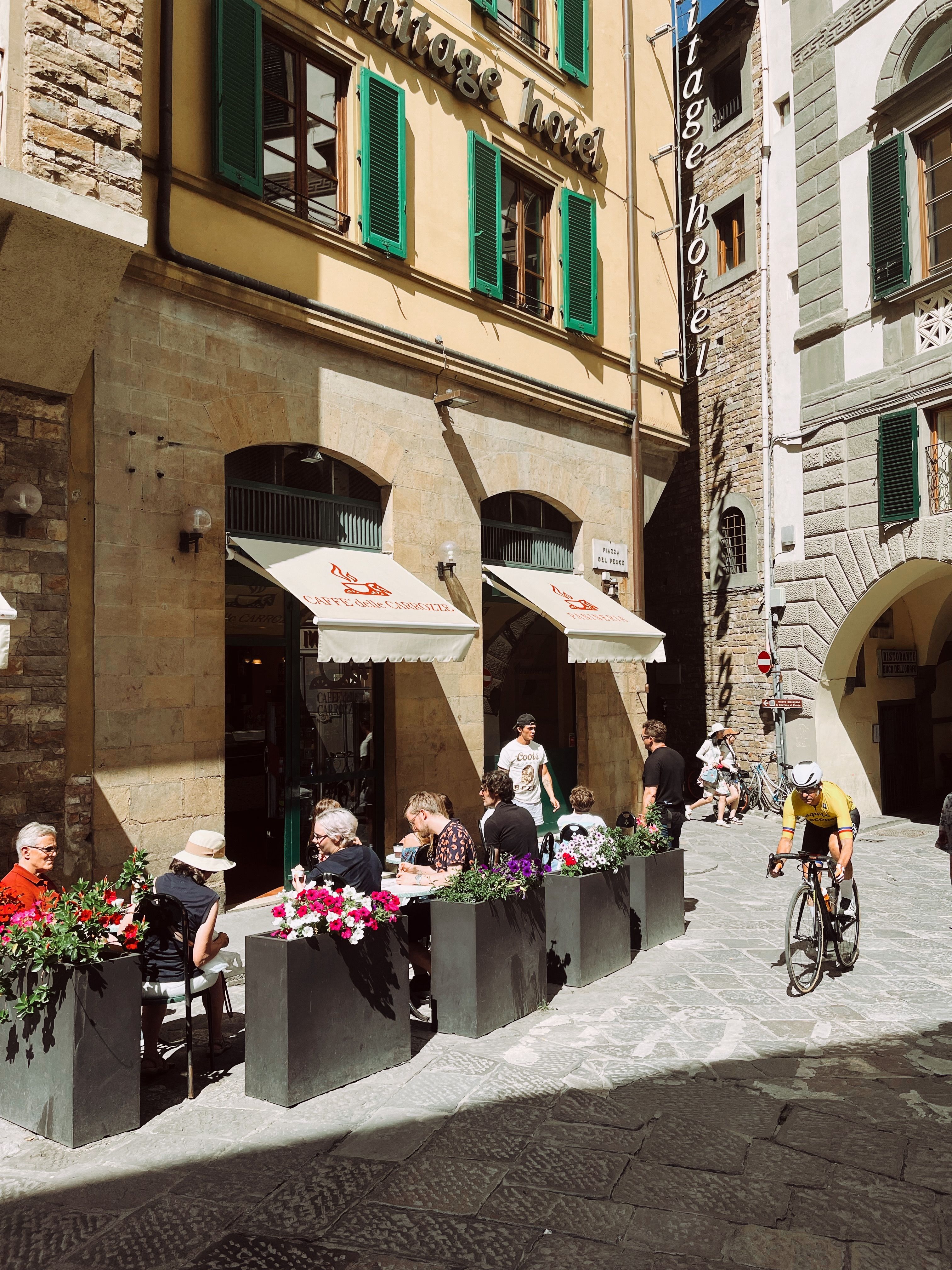 Vibrant outdoor café in a sunlit street of Florence, Italy, capturing local life.