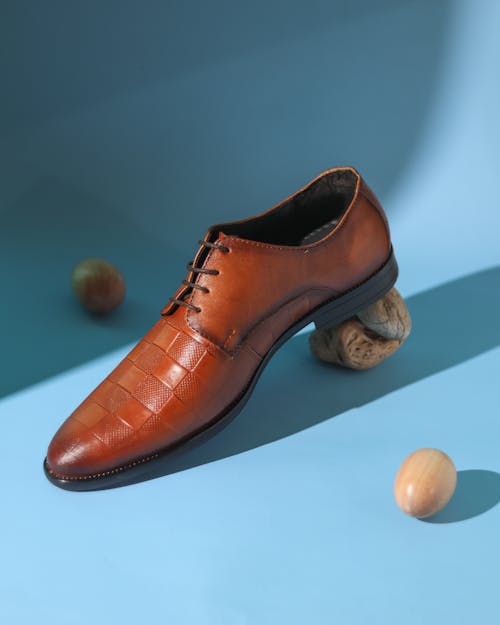 Free A pair of brown shoes on a blue surface Stock Photo