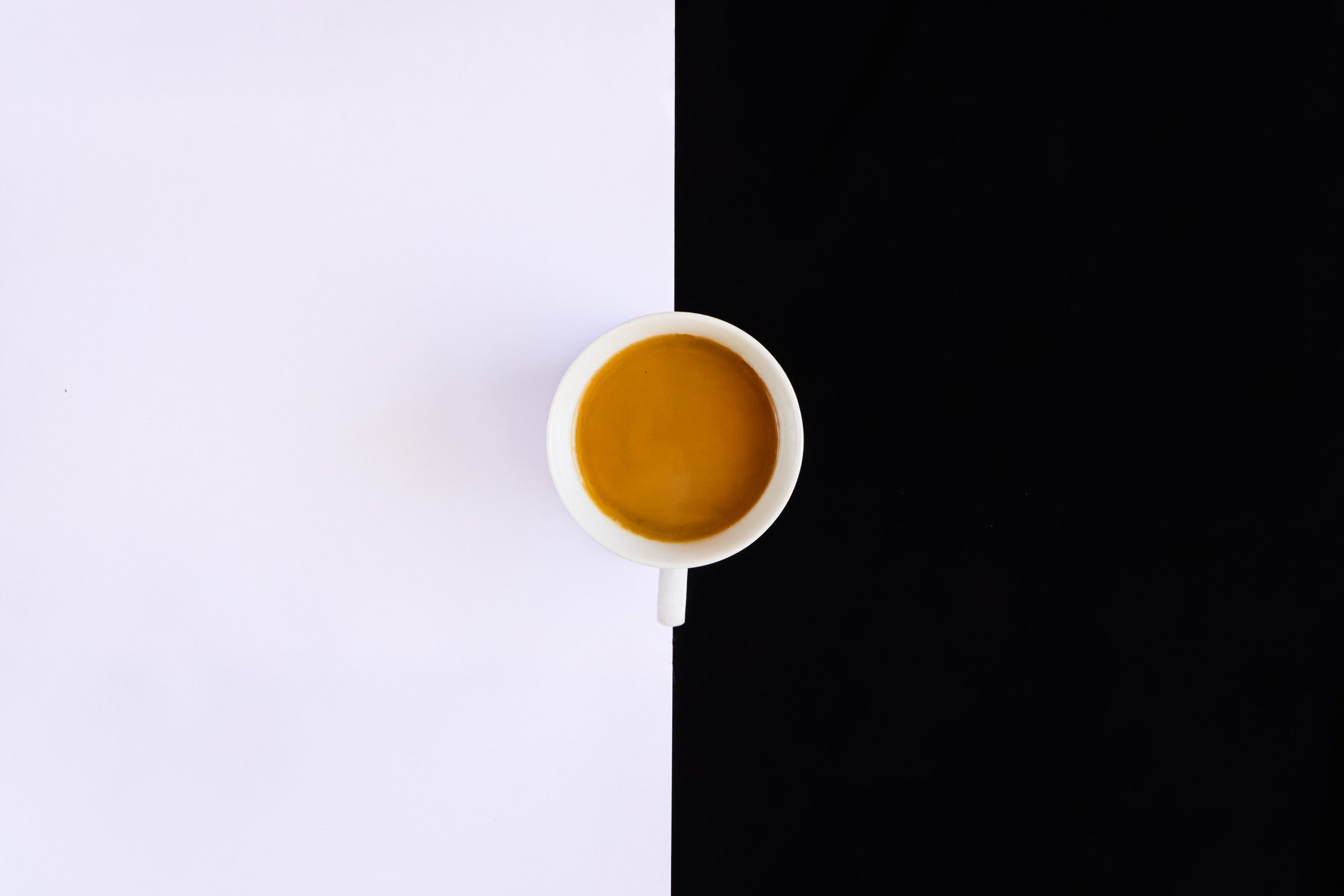 A top-down view of a coffee cup on a contrasting black and white background.