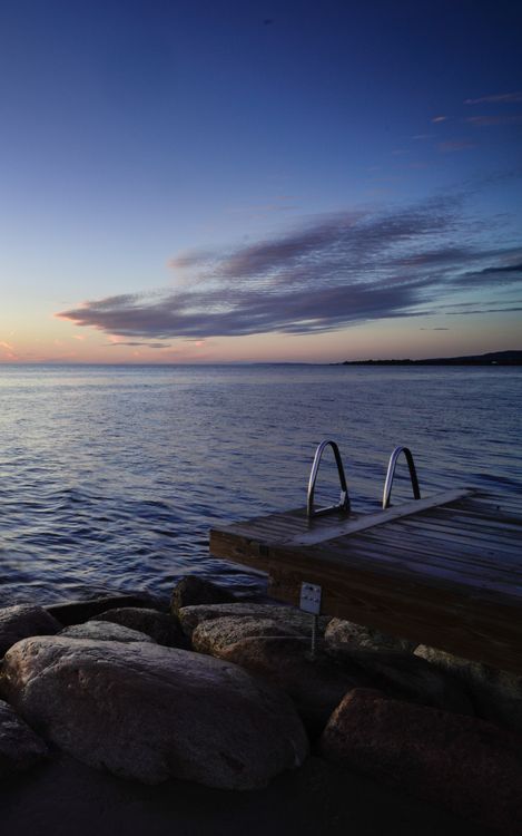 A dock with a railing and a rock wall · Free Stock Photo