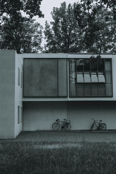 Monochrome image of modern residential architecture with two bicycles and minimalist design.