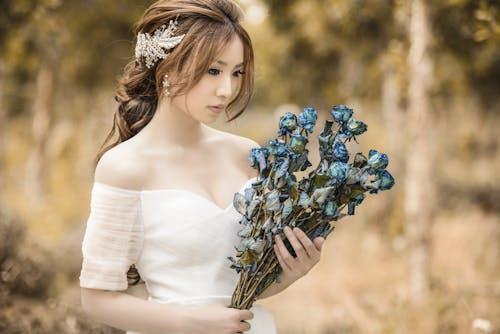 grátis Mulher Segurando Flores Azuis Foto profissional