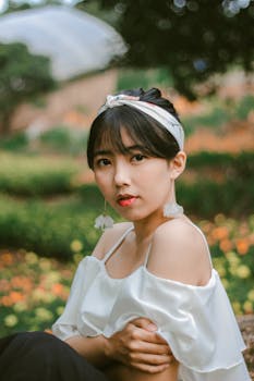 一位时尚的亚洲年轻女子在充满活力的花园中摆出户外姿势