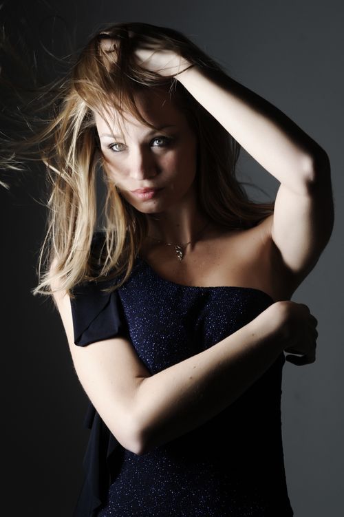 Free Portrait of a fashionable woman posing elegantly in a studio setting. Stock Photo