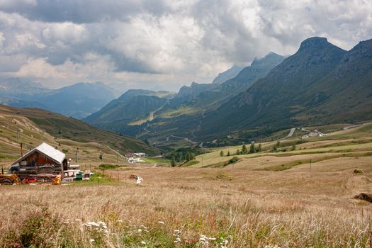 Beautiful alpine valley landscape featuring a rustic farmhouse surrounded by mountains.