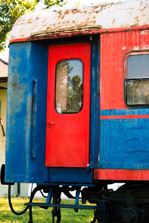 A red and blue train car with a door open