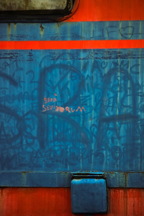 A graffiti covered train with a red and blue paint