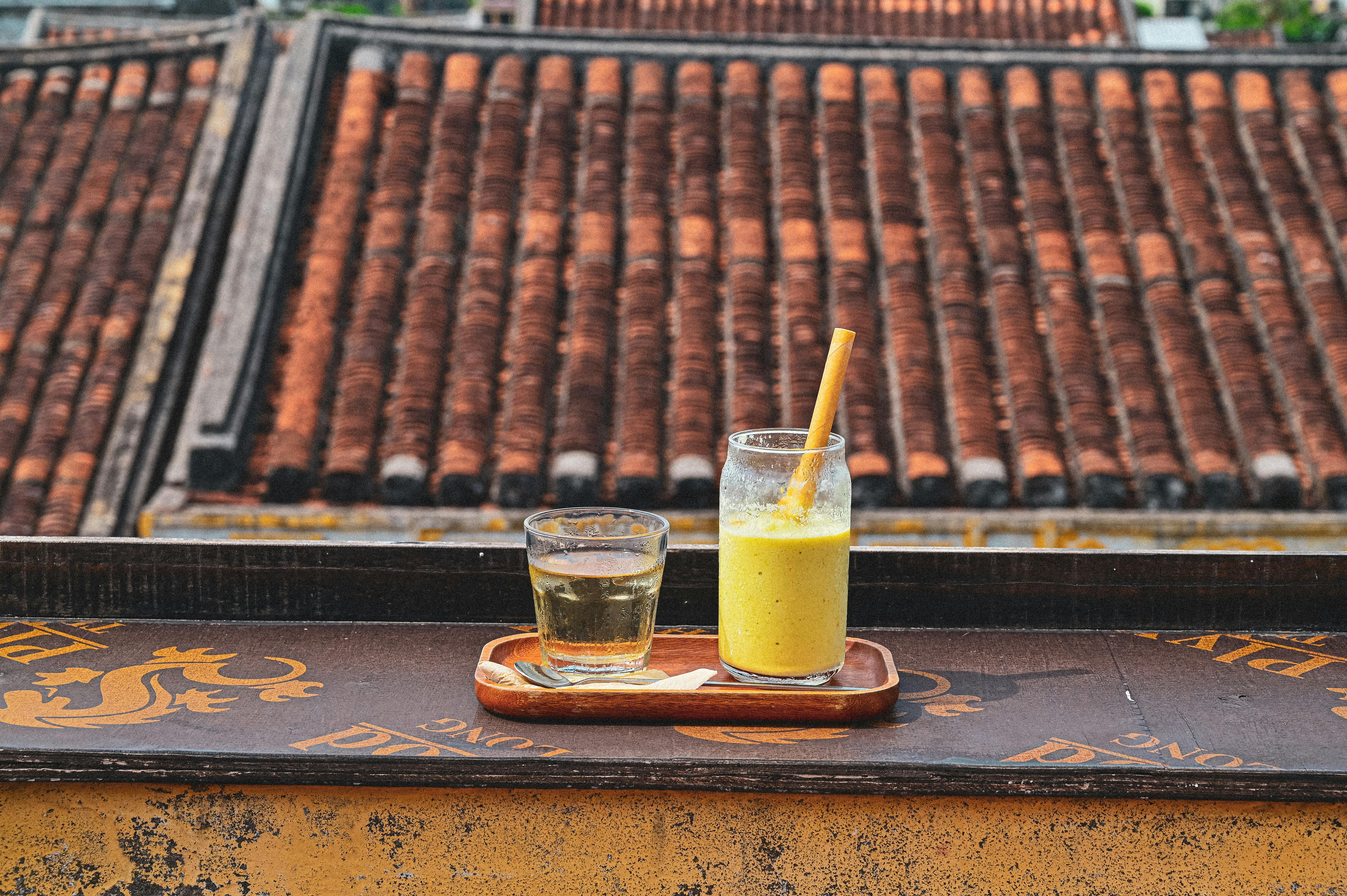 Refreshing drinks on a rooftop balcony in Hội An, Vietnam with classic tiles.