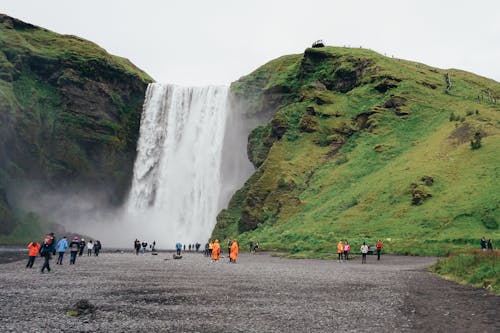 People Standing Near Waterfalls