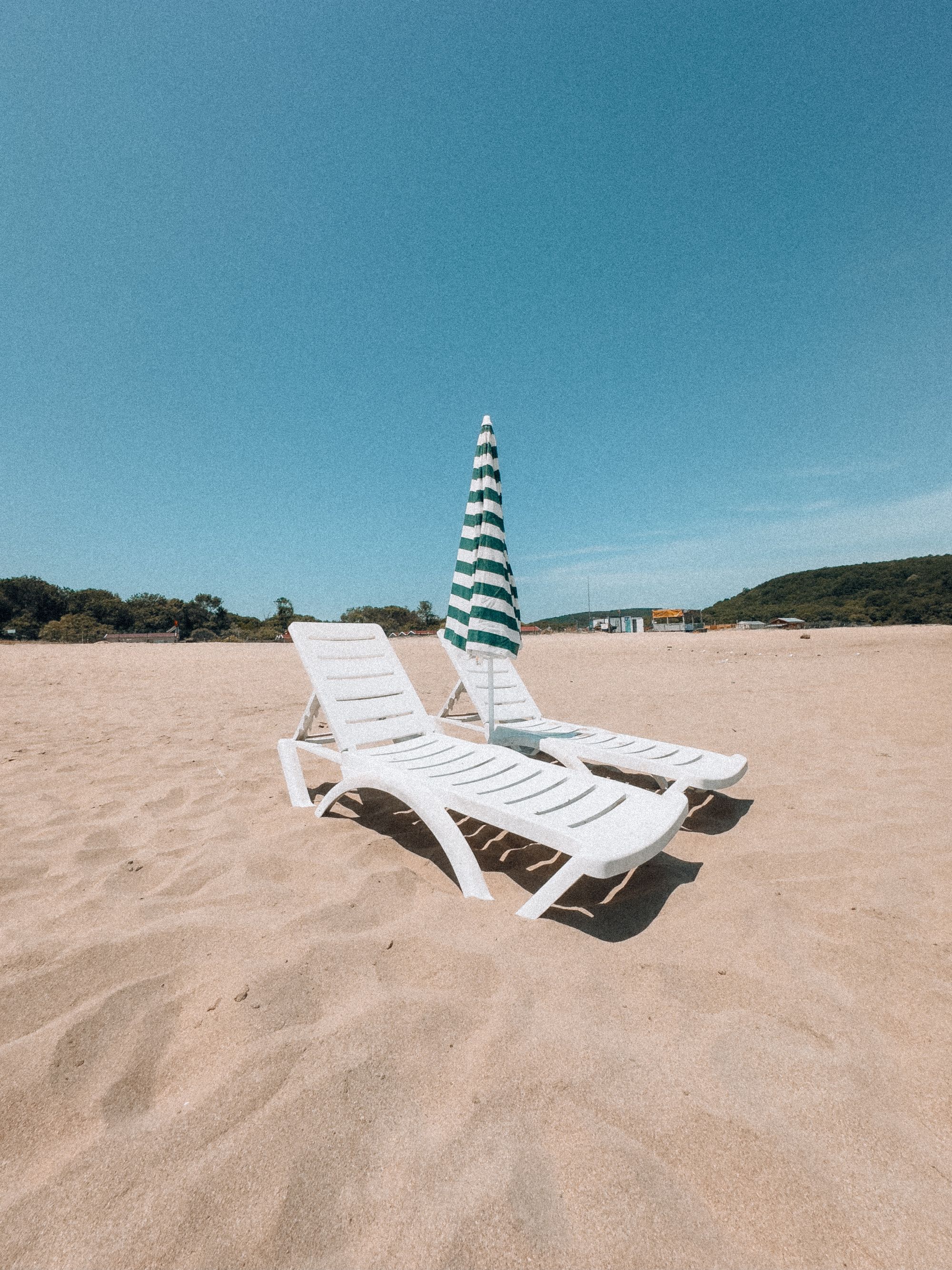 Beach loungers and shade arranged beside the sea for coastal relaxation