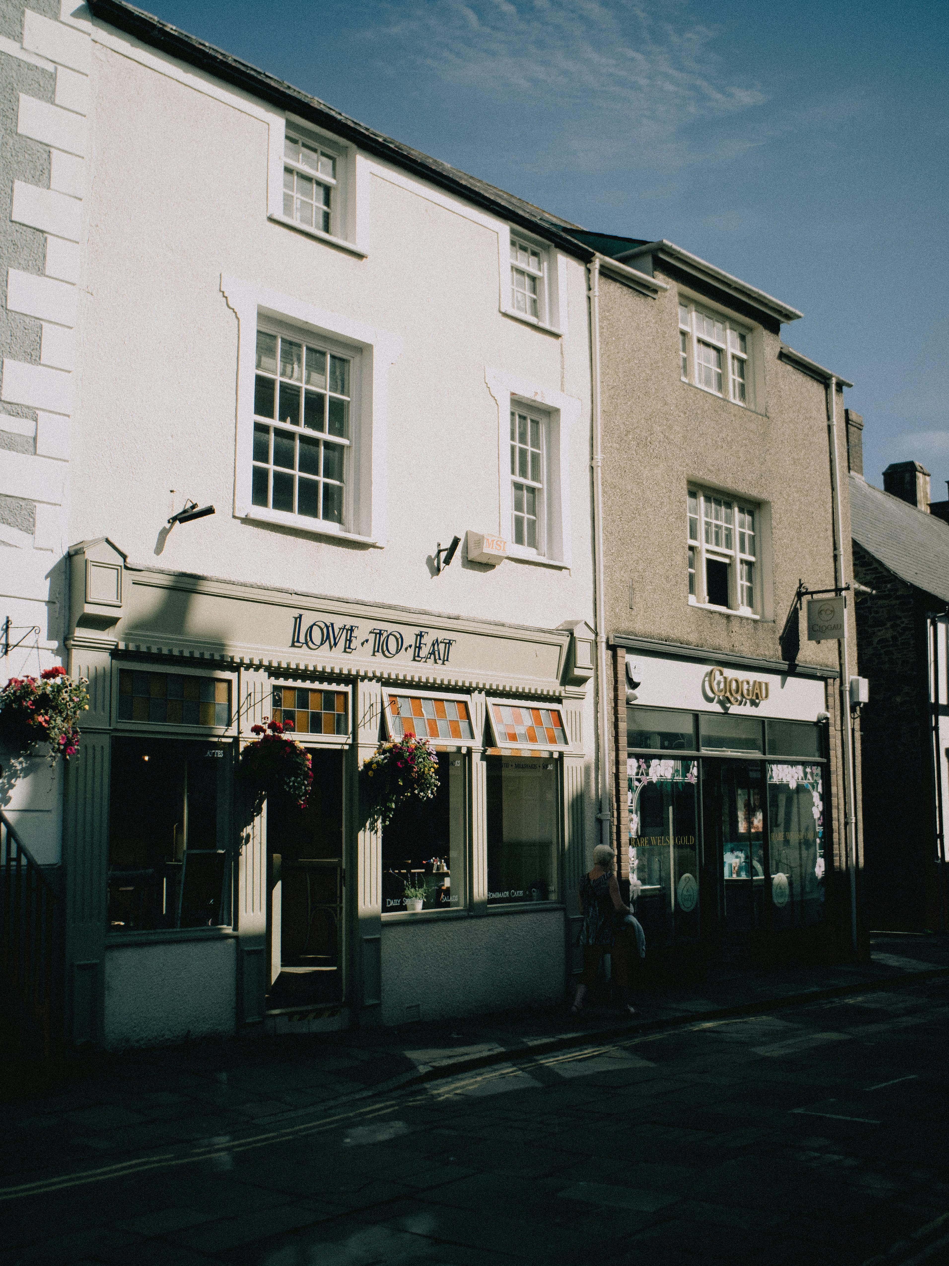 Picturesque view of a café lined street in Conwy, Wales, under a sunny sky.
