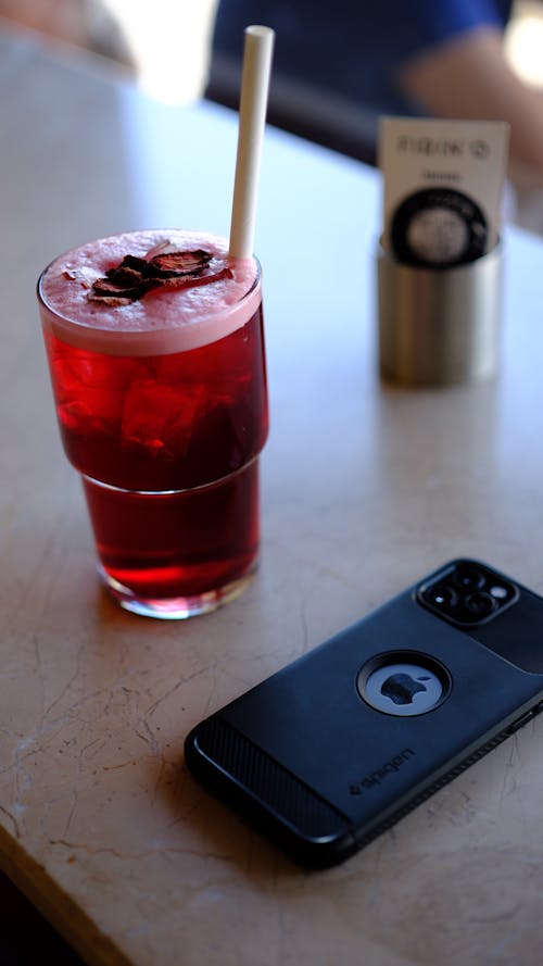 A phone and a drink on a table