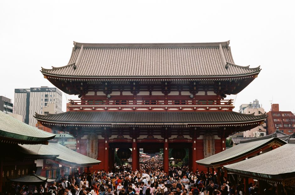 A vibrant crowd gathers at the historic Senso-ji Temple in Tokyo, Japan, showcasing cultural architecture.