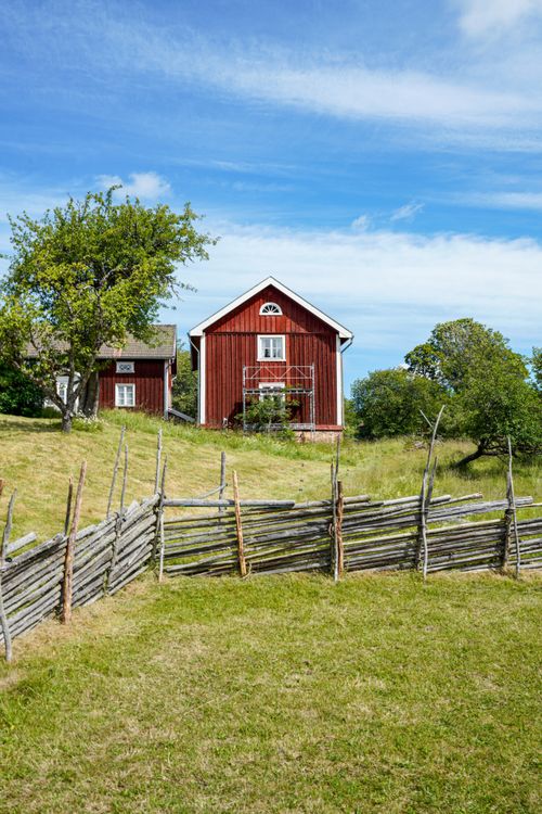 Free A charming rustic barn surrounded by greenery, showcasing serene rural life. Stock Photo