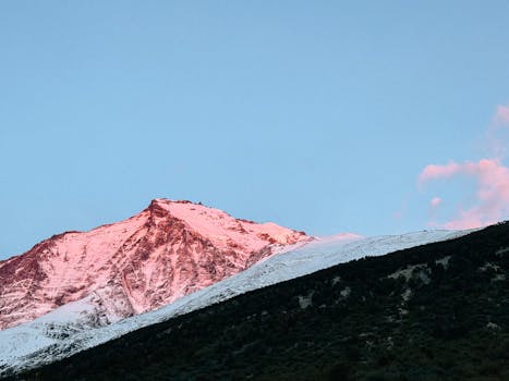 A breathtaking pink sunrise illuminates snow-capped mountains in the Chilean region of Магальянес-и-ла-Антарктика-Чилена.