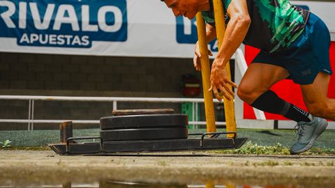 Man pushing sled in outdoor stadium reflects strength and determination.