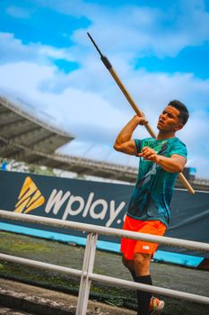 Man preparing for a javelin throw in stadium setting under blue sky. — photo by Pipe Vasquez