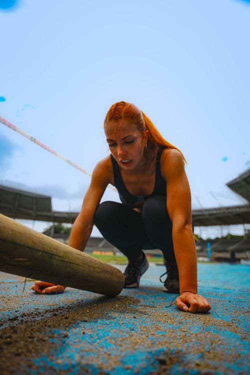 Free Determined female athlete tackles an obstacle in an outdoor competition, showcasing strength and focus. Stock Photo