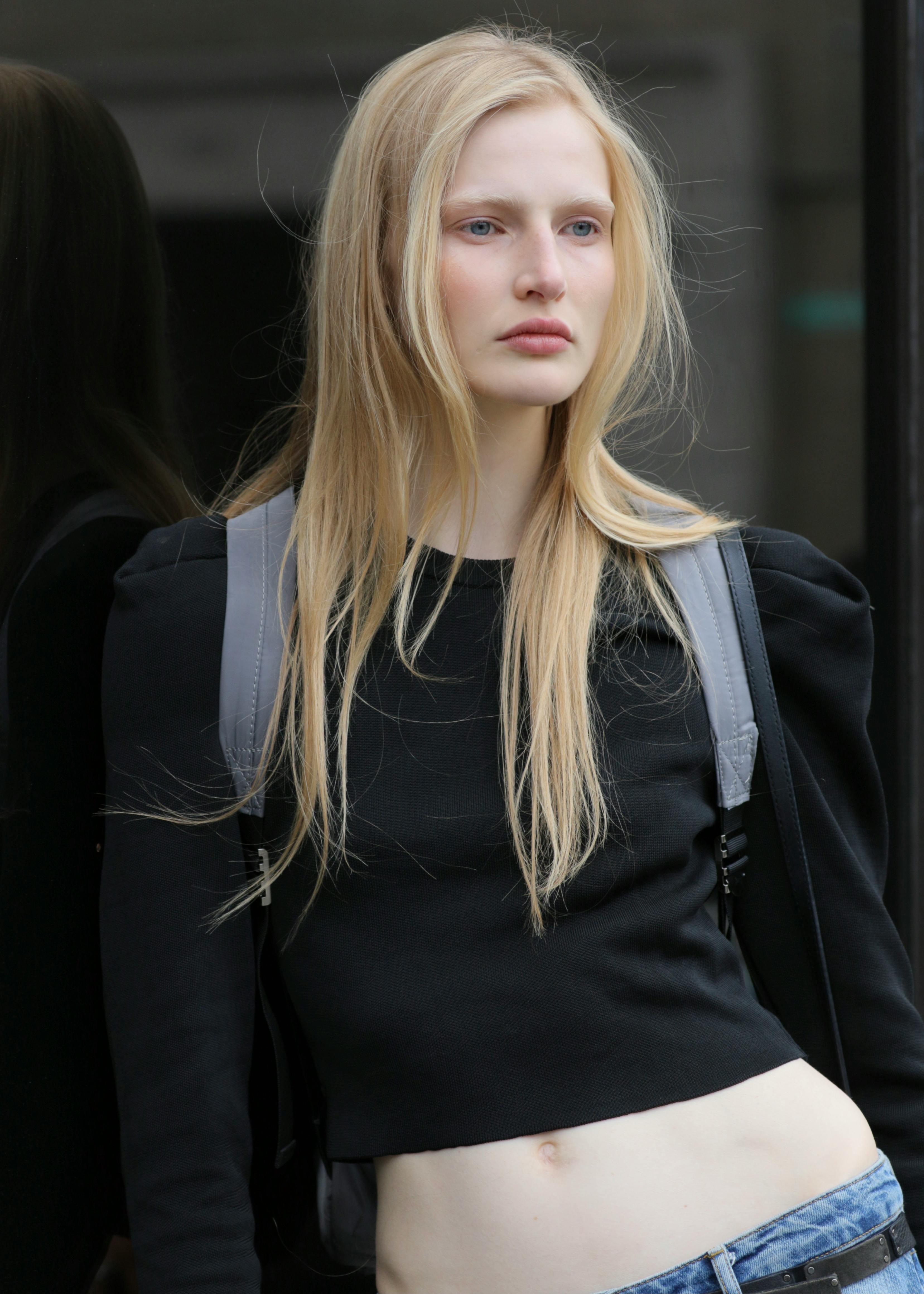 Stylish young woman with long hair in urban fashion setting.