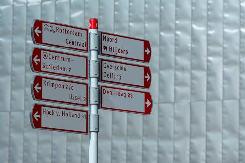 A red and white directional sign pointing to different directions