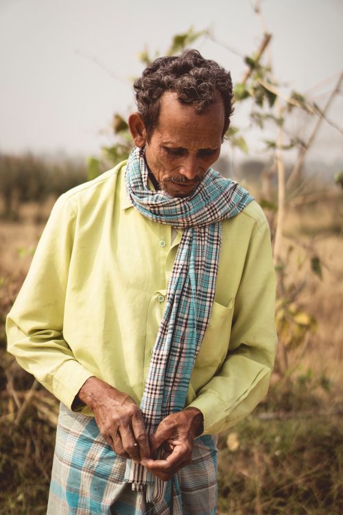 Free Elderly man in rural setting, wearing a plaid scarf, autumn ambiance. Stock Photo