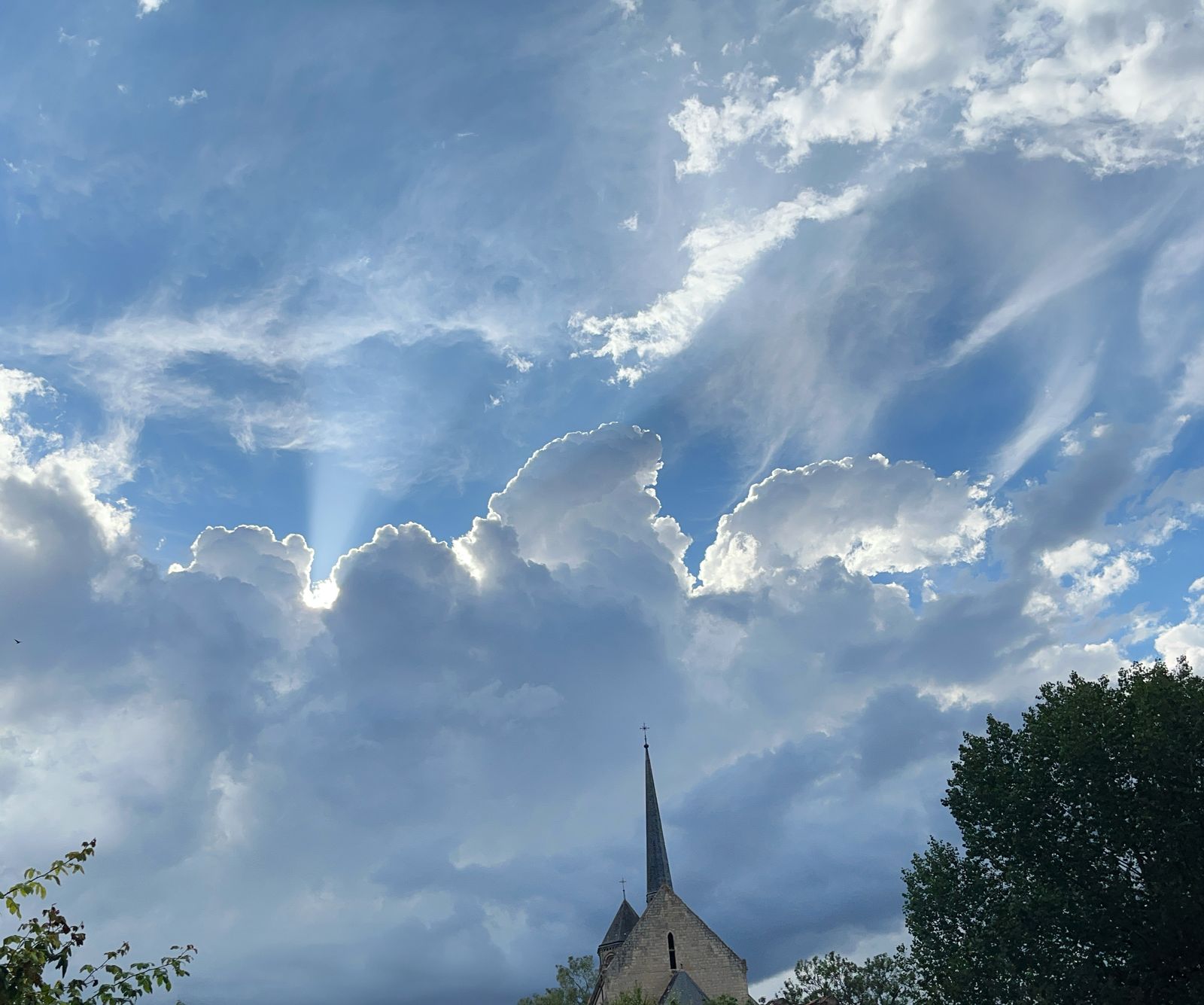 Rayons de soleil à travers des nuages spectaculaires au-dessus d'un clocher