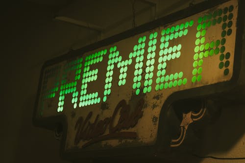 A neon sign that says reme in green letters