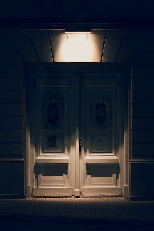 A door is lit up at night in a dark street