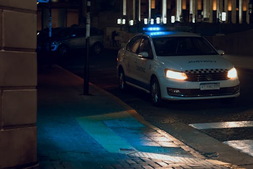 A police car driving down a street at night