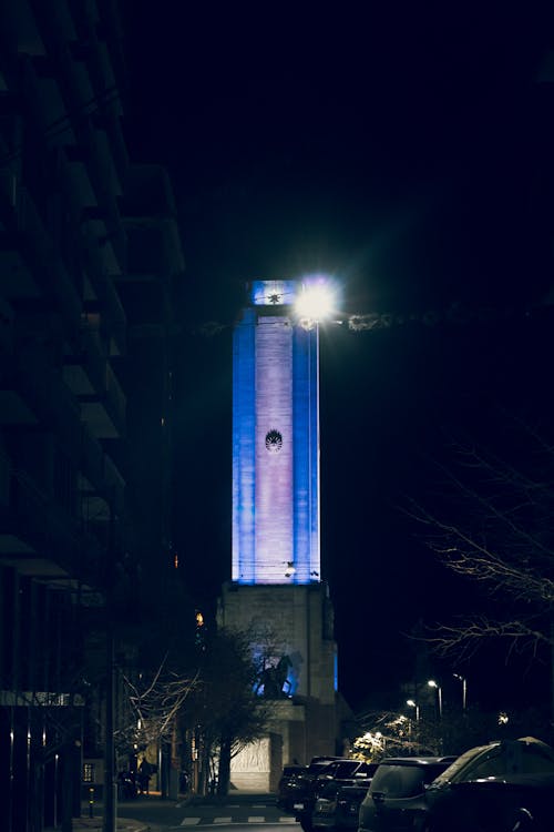 A blue light tower is lit up at night