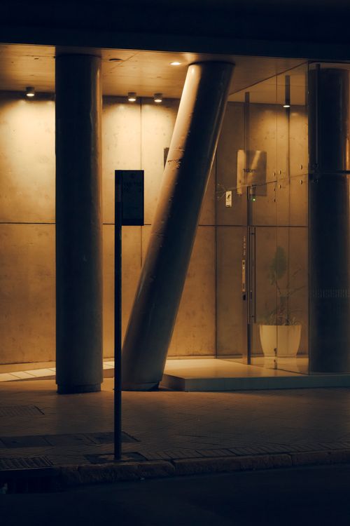 Free Nighttime view of a modern building entrance with illuminated columns in Rosario, Argentina. Stock Photo