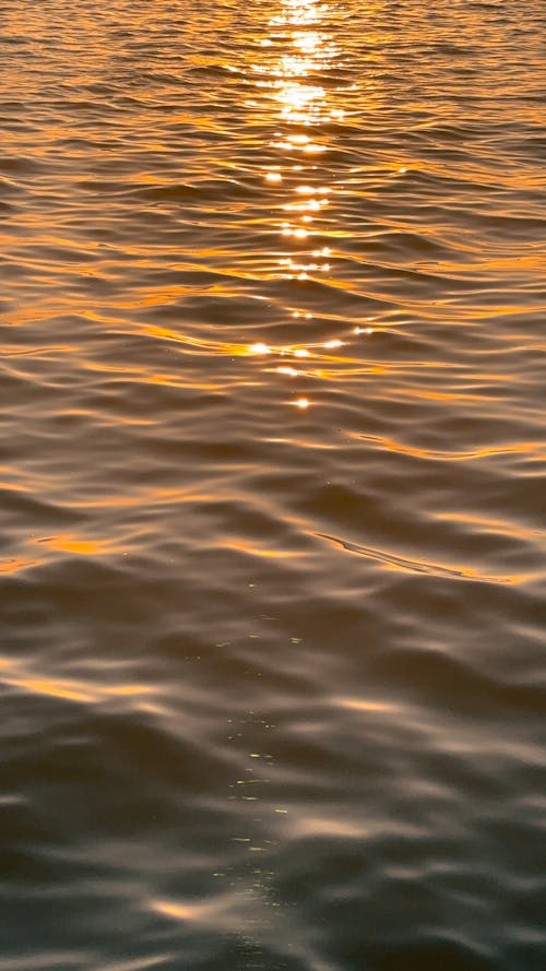 A sunset over the water with waves