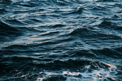 Free A breathtaking view of ocean waves in motion with deep blue tones. Stock Photo