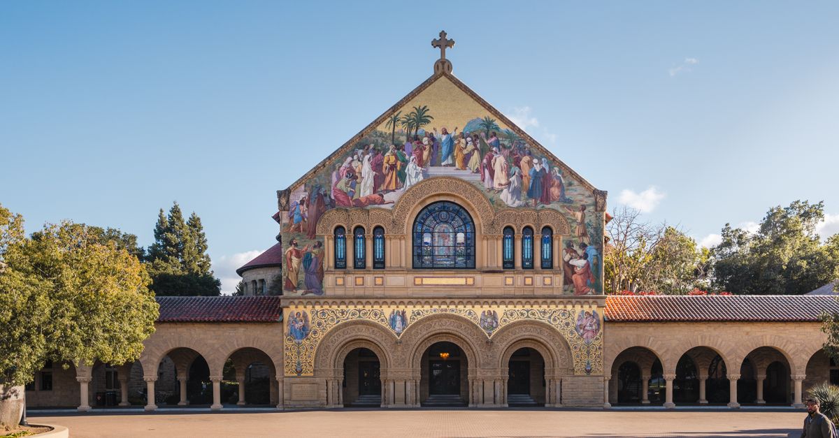 The iconic Stanford Memorial Church with detailed facade under a bright blue sky at Stanford University.
