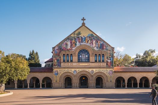 The iconic Stanford Memorial Church with detailed facade under a bright blue sky at Stanford University.