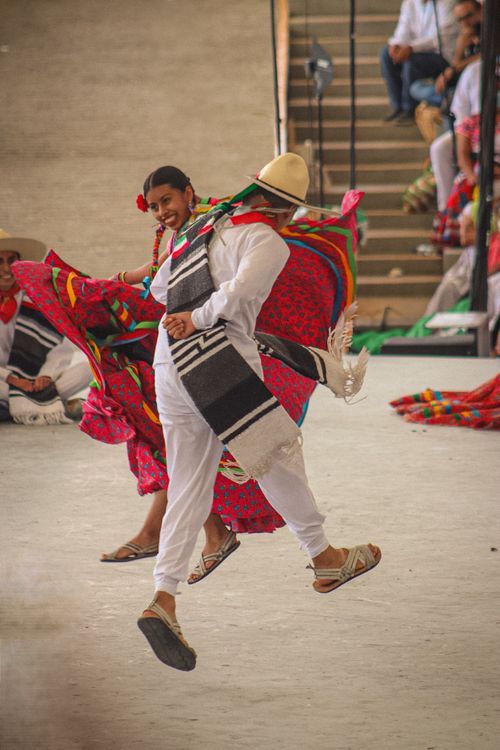 Free Vibrant Mexican dancers in traditional attire performing at a cultural festival in Oaxaca. Stock Photo