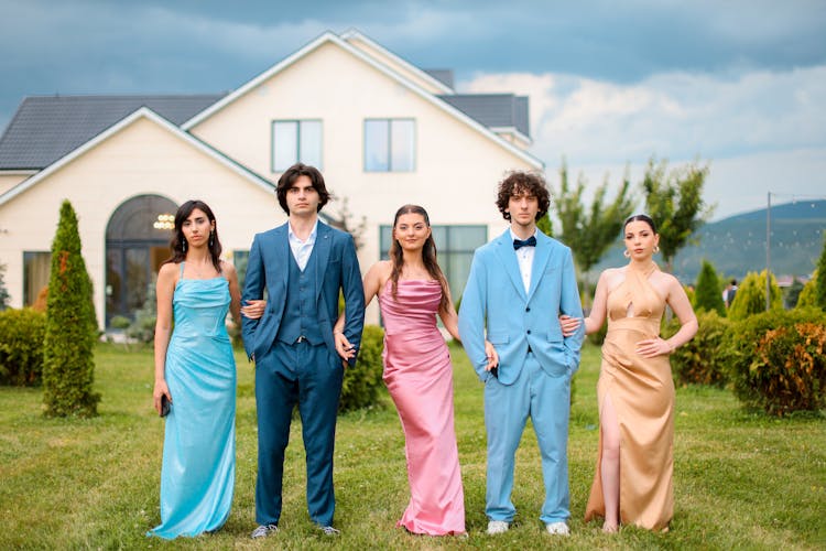 A Group Of People Standing In A Garden