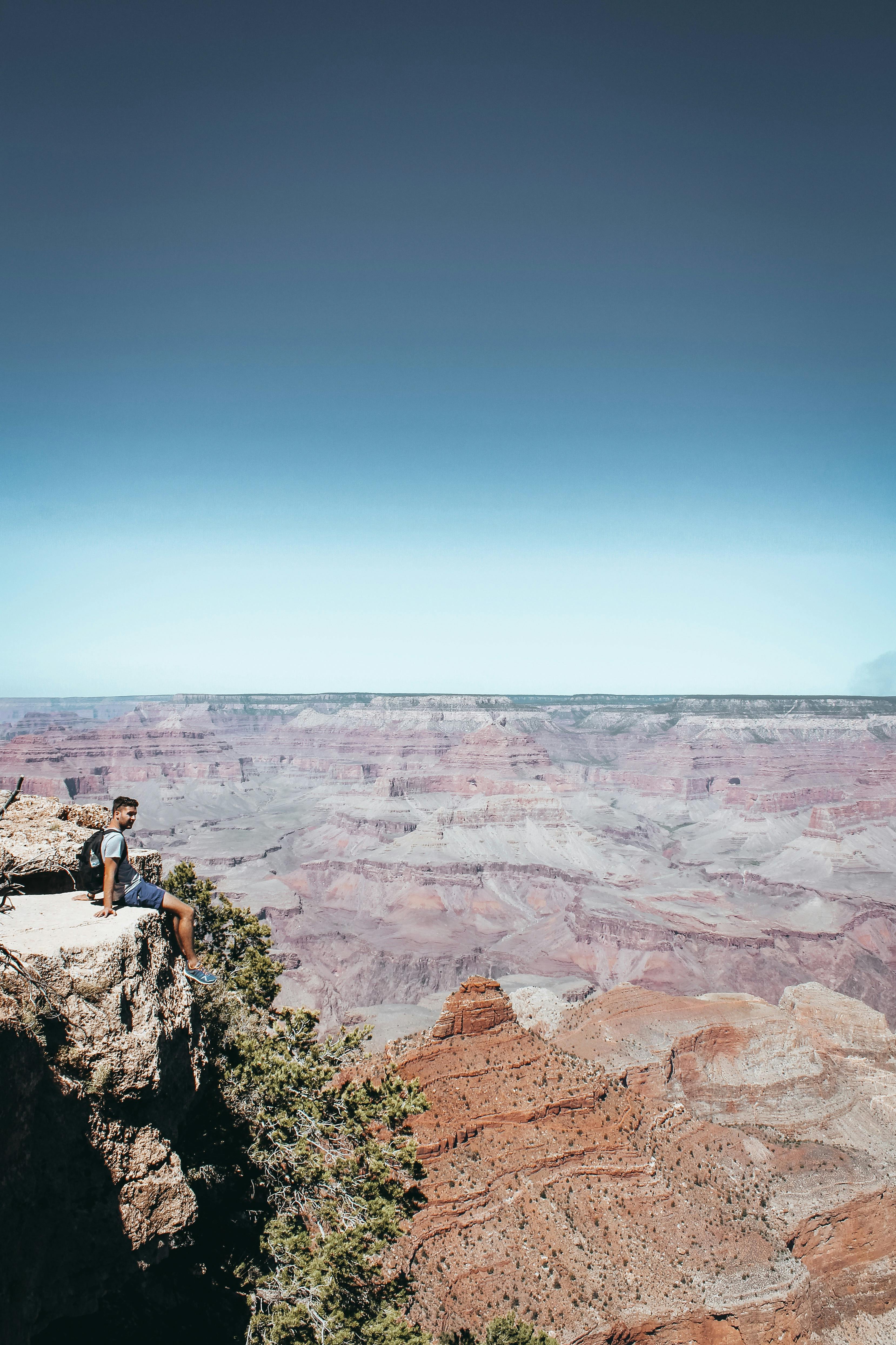 在大峡谷边缘，一位孤独的徒步旅行者欣赏着令人惊叹的景色
