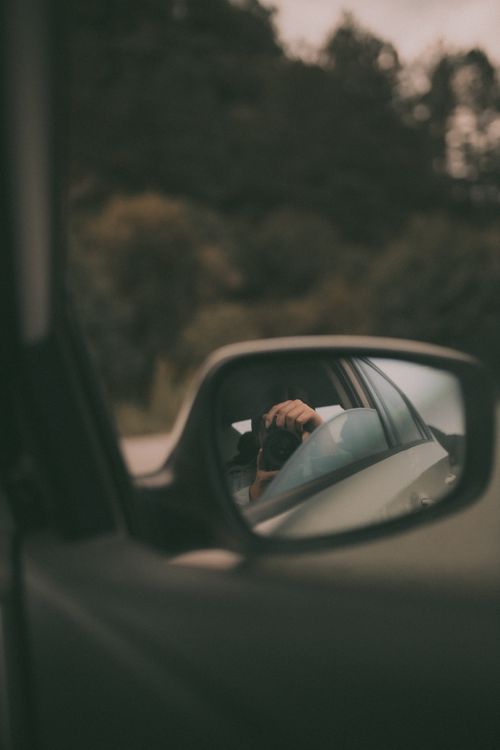 Free Reflective shot of a photographer in a car mirror, highlighting artistic expression. Stock Photo