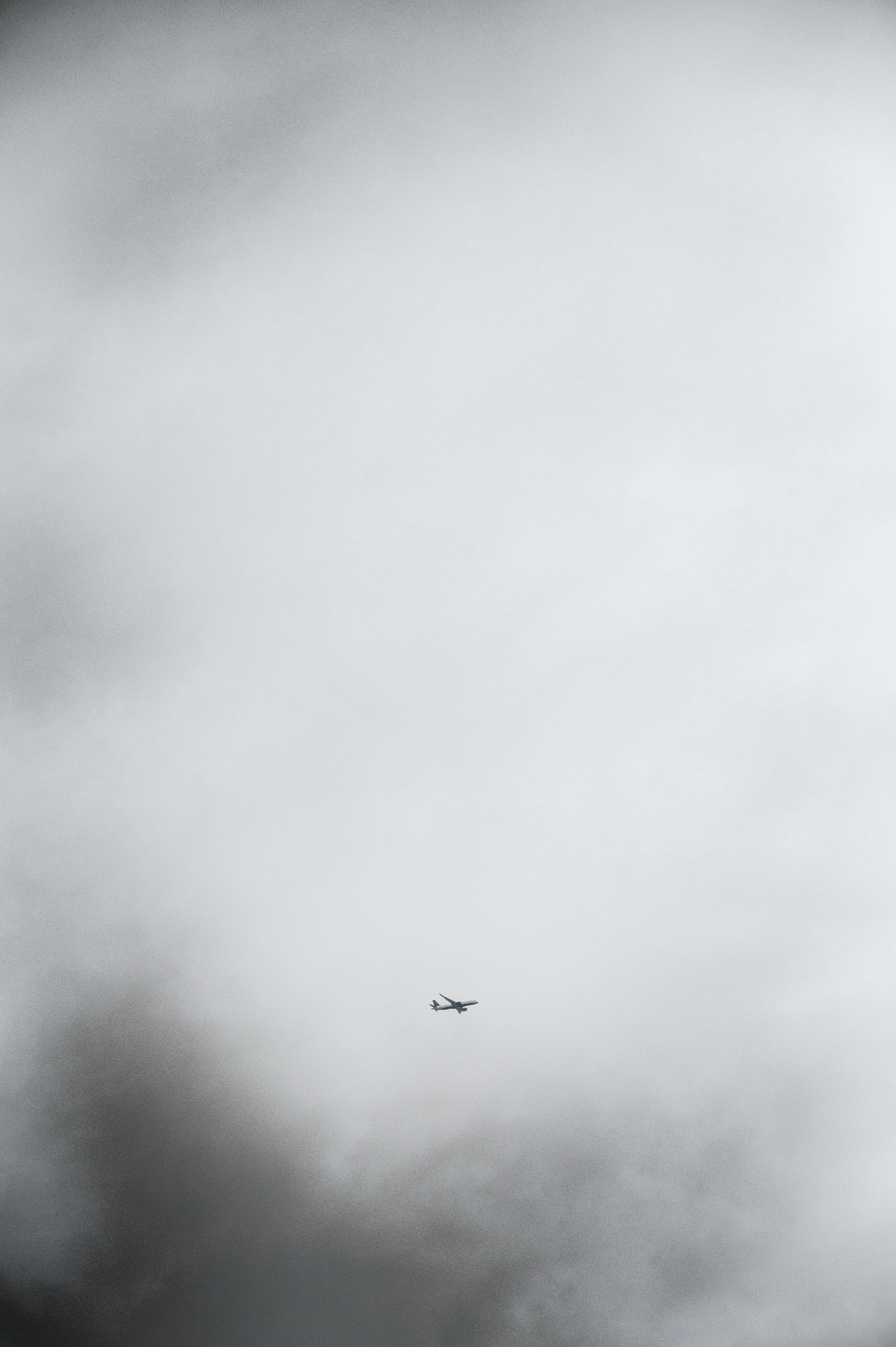 A distant airplane flying through an overcast sky in Seattle, Washington.
