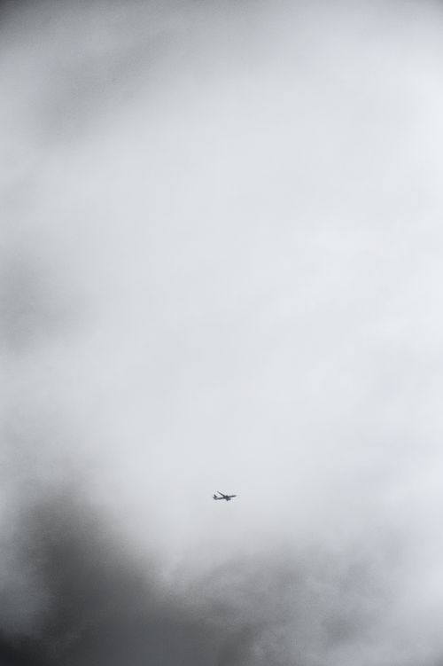 Free A distant airplane flying through an overcast sky in Seattle, Washington. Stock Photo