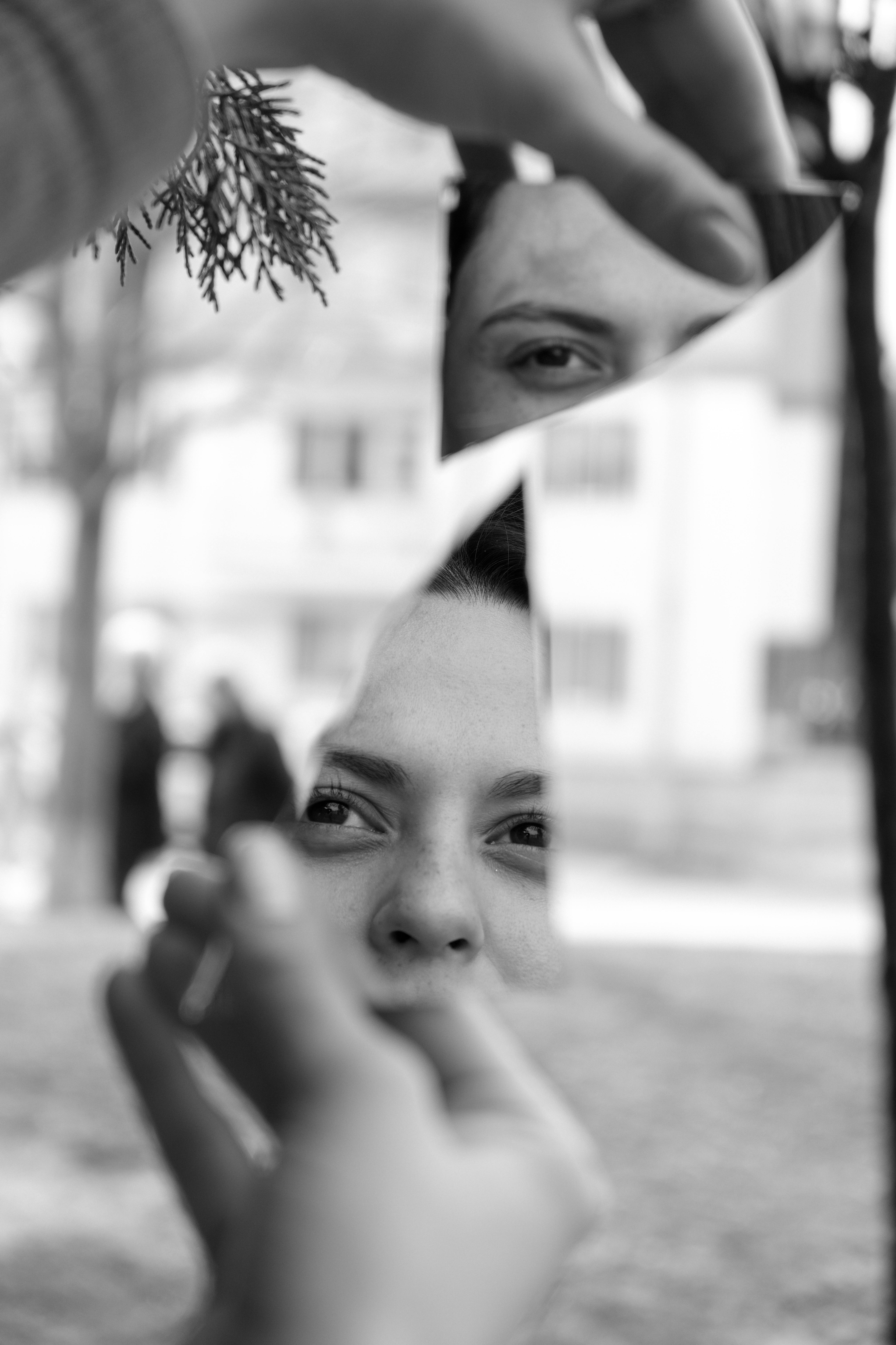 A woman's face reflects in shards of a broken mirror, creating a unique urban art scene.
