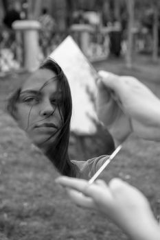 Artistic black and white portrait using a broken mirror for a unique reflection.
